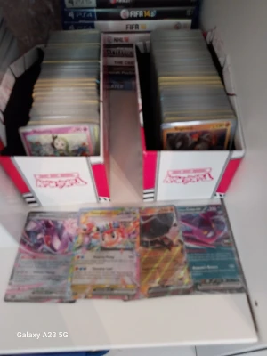 Stor samling Pokémonkort i boxar - Säljer en stor samling Pokémonkort i två vita och röda samlarboxar. Blandningen innehåller både vanliga och holografiska kort med olika motiv och färger. Perfekt för dig som vill utöka din samling eller börja samla Pokémonkort.