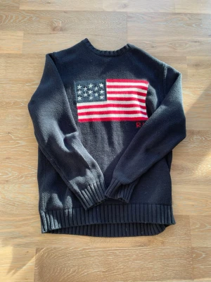 Mörkblå flag sweater från Ralph Lauren - Snygg mörkblå stickad tröja från Ralph Lauren med stor amerikansk flagga på bröstet. Storlek S, hör av er vid frågor. Priset är diskuterbart.