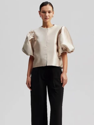 Champagnefärgad puffblus By Malina - Snygg champagnefärgad blus från By Malina med puffiga korta ärmar och rak passform. Tillverkad i ett glansigt, satinliknande material som ger en lyxig känsla. Nypris 2200 kr