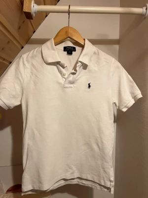 Vit pikétröja från Polo Ralph Lauren - Klassisk vit pikétröja från Polo Ralph Lauren med korta ärmar. Tröjan är storlek M men passar xs bäst. Kontakta vid minsta fundering