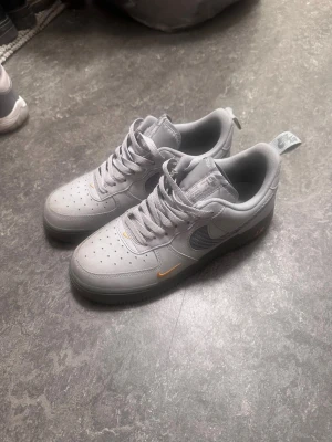 Nike Air Force 1 grå customs - Grå Nike Air Force 1 sneakers som är custom gjorda och är i ganska bra skick. Den har lite smuts på sig fast inte något man inte kan ta bort me lätt rengöring.