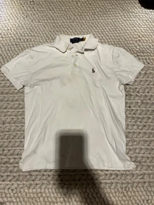 Ralph Lauren pikétröja  - Klassisk vit pikétröja från Ralph Lauren. Den är i bra skicka med inga som helst difekter. Den kan passa xs eller mindre