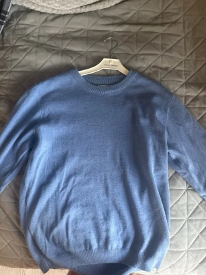 Ljusblå stickad tröja Zara  - Mysig ljusblå stickad tröja från Zara med rund halsringning och ribbade muddar vid ärmslut och nederkant. Perfekt för lager på lager och enkel att matcha till jeans eller kjol. Materialet känns mjukt och behagligt.