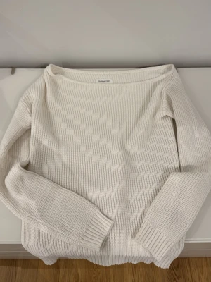 Vit ribbstickad tröja even&odd off the shoulder  - Klassisk vit ribbstickad tröja från even&odd off the shoulder och långa ärmar. Tröjan har breda muddar vid ärmslut och nederkant, och är tillverkad i ett mjukt, tjockare material som passar perfekt för kyligare dagar.