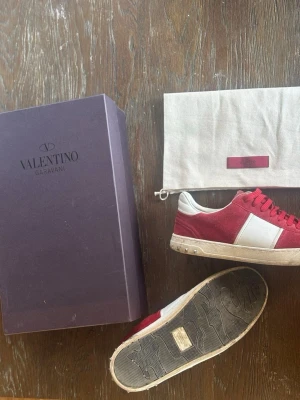 Valentino Garavani sneakers röd/vit - Säljer mina Valentino Garavani sneakers i röd/vit färg. Kommer med box och dustbag.  Använda men fortfarande i bra skick, visst slitage på sulan (se bild). Passar till både vardag och finare outfits.  Storlek: 41 (stora i storleken) Nypris: 7000 kr  Säljes pga används inte längre.  Pris: 2500 kr