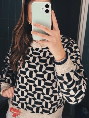 Beige och mörk grön stickad unik tröja - Stickad tröja från ONLY i beige och svart/mörk grönt med grafiskt mönster. Tröjan har rund halsringning och ribbade muddar vid hals, ärmslut och nederkant. Perfekt för dig som gillar en unik och trendig look.