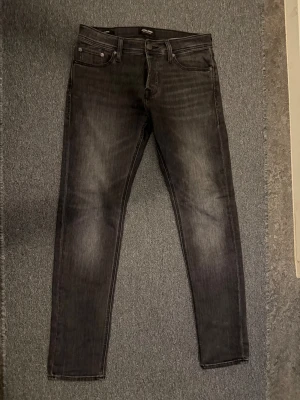 Jack and Jones Svarta slim fit jeans  - Ljus svarta Jack & Jones jeans i mycket bra skick. Väldigt stilrena och enkla att matcha till både vardag och finare outfits. Bekväma i passformen och knappt använda. Perfekta för dig som vill ha ett par snygga jeans till bra pris