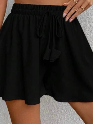 Svarta shorts med snörning storlek M - Säljer ett par svarta shorts med bred resår i midjan och snörning framtill. De har en loose passform och är perfekta för varma dagar. Materialet känns mjukt och bekvämt, troligen bomull eller polyester. Passar till många olika stilar!