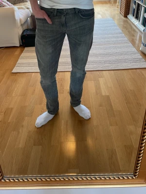 Grå slim fit jeans - Säljer ett par grå slim fit jeans med klassisk femficksmodell och normal midja. Jeansen har en snygg tvättad look och raka ben. Passar perfekt till en avslappnad stil och är tillverkade i ett mjukt denimtyg med lite stretch. Köpta för 1800kr