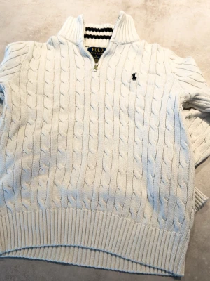 Vit/kräm färgad stickad tröja från Ralph Lauren - En sjukt snygg stickad tröja från Ralph Lauren i barnstorlek M (Ca 152) den är i riktigt bra skick så hör bara av er vid funderingar och jag skickar inom en dag!