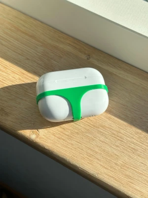 AirPods Pro 3 "Thong" Case – Grön - Ge dina AirPods en humoristisk twist! Detta minimalistiska skydd i form av en stringtrosa är den ultimata snackisen. Modellen är specifikt framtagen för perfekt passform på AirPods Pro 3. • Material: 3D-utskriven PLA. • Färg: Grön. • Info: Behöver du skydd till en annan AirPods-modell? Kika gärna på mina andra annonser! 