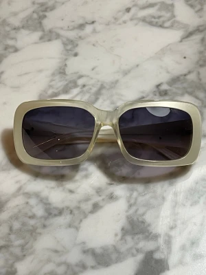 Stora vita fyrkantiga solglasögon från Esprit  - Snygga solglasögon från Esprit med bred, vit båge och stora fyrkantiga linser i mörk ton. Riktigt trendig retrostil som ger en cool vibe till din look. Perfekta för dig som vill sticka ut och addera lite edge till outfiten.