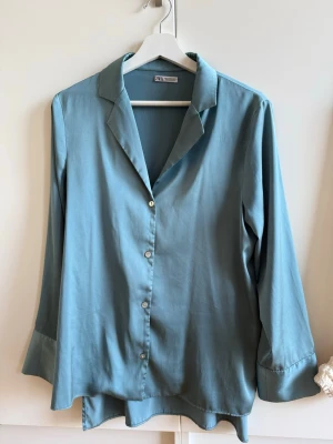Blå satinskjorta Zara - Blå satinskjorta från Zara i storlek XS 💙  Klassisk och stilren modell som passar perfekt till både vardag och jobb.  I fint skick. Säljer då den inte kommer till användning ✨
