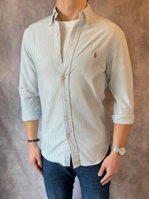 Randig Ralph Lauren Skjorta - Stl S, Slim fit - RIKTIGT FET RL SKJORTA I RANDIGT MÖNSTER MED FÄRGERNA BLÅ OCH VIT, perfekt till sommaren som närmar sig! 🏖️🌊 | Mycket bra skick: 9,5/10, utan defekter! | Stl: S |  Modellen är 176cm och väger 75kg,  | Hör av dig vid frågor // Galgen 🫡