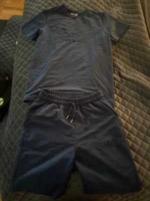 Nike Air set - Säljer ett blått set med t-shirt och matchande shorts. Båda delarna har diskret AIR-brodyr framtill. Shortsen har resårmidja med dragsko och sidofickor. Perfekt för en avslappnad och sportig look.