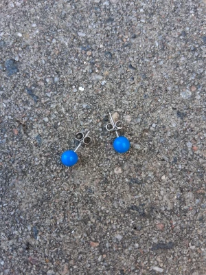 Blå pärlörhängen i silverfärg - Säljer ett par stilrena örhängen med blå pärlor i plast och silverfärgade stift. Perfekta för dig som vill ha en färgklick till din outfit. Klassisk rund form och enkel design som passar till många stilar.