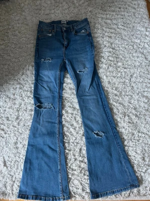 blås jeans med egengjorda hål - blåa jeans med hål