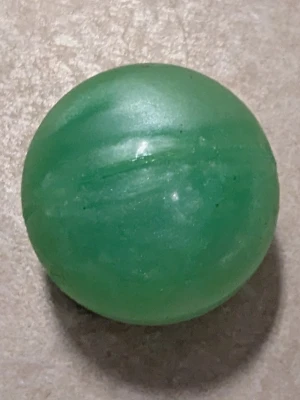Grön studsboll i plast - En klassisk grön studsboll i plast med marmorerat mönster. Perfekt för att studsa mot golv eller väggar och ha kul med vänner. Bollen är rund och har en slät yta.