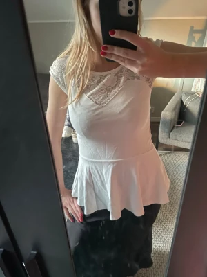 Vit peplumtop med spetsdetaljer - Säljer en söt vit peplumtop med spets upptill och korta ärmar🌸
