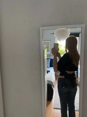 Svart tie-topp - Säljer en svart croppad topp med snygg knytning i ryggen. Toppen har en enkel, stilren design och är perfekt för dig som gillar trendiga detaljer. Materialet känns mjukt och bekvämt.