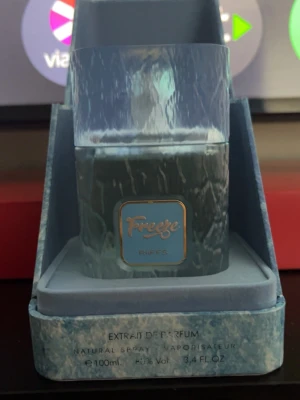 Freeze Parfum 100ml - Freeze Extrait de Parfum från Riffs i en snygg blå och vit marmorerad flaska med matchande förpackning. Flaskan har en fyrkantig form och ett blått emblem med gulddetaljer på framsidan. Innehåller 100 ml naturlig spray.