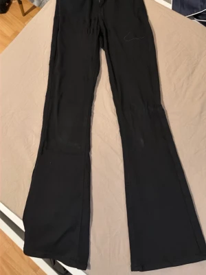 Svarta utsvängda leggings - Säljer ett par svarta leggings med utsvängda ben. De har hög midja och är tillverkade i ett stretchigt material som sitter skönt på kroppen. Perfekta för en trendig och avslappnad look.