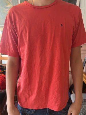Röd t-shirt  - En enkel röd t-shirt från park lane med liten diskret logga på bröstet. T-shirten har rund halsringning och korta ärmar. Tillverkad i mjuk bomull för en bekväm känsla och passar perfekt till jeans eller shorts.