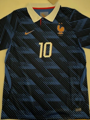 Kylian Mbappe Frankrike Vm 2026  - Fotbollströja i helt nytt och oanvänt skick med tag kvar. Detaljrik design och bekvämt material som passar både till match och vardag. Detta är en inofficiell version av modellen. Storlek S