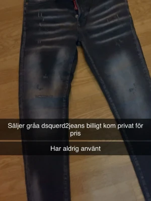 Gråa Dsquared2 jeans med slitningar - Säljer ett par gråa jeans från Dsquared2 med coola slitningar och tvättade detaljer. Jeansen har klassisk femficksmodell och smal passform. Perfekta för dig som gillar streetwear och vill ha en trendig look.