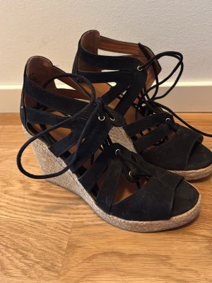 Svarta sandaler - Snygga svarta sandaler med kilklack och snörning runt vristen. Använt endast 1 gång
