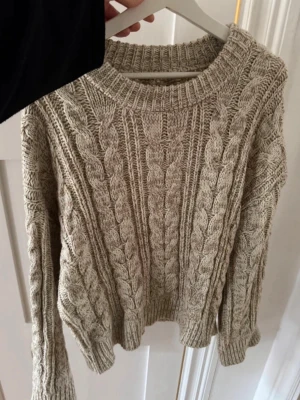 Stickad tröja  - Säljer en oanvänd oversized kabelstickad tröja från Hanna Schönberg X NA-KD. Tvättlappen är däremot inte kvar. 