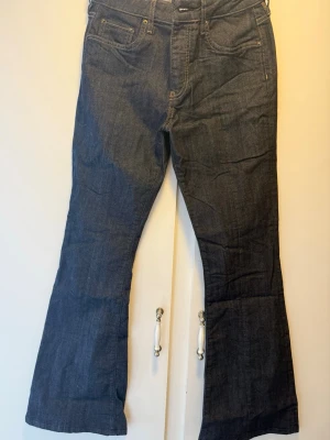 Mörkblå bootcut jeans från Avora - Snygga mörkblå jeans med bootcut passform och klassiska fem fickor. Jeansen har normal midja och är tillverkade i denim med lätt stretch. Perfekta för dig som gillar en retroinspirerad look med utsvängda ben.