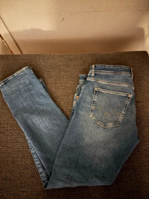 Replay jeans  - Säljer ett par klassiska blå slim fit jeans med snygga sömmar på bakfickan. Jeansen har normal midja och raka ben. Perfekta till vardags och lätta att matcha med olika stilar. Materialet är mjukt denim som ger en bekväm känsla.