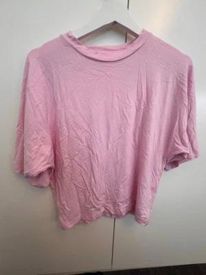 Ljusrosa oversized t-shirt - En enkel och stilren ljusrosa t-shirt i oversized modell. T-shirten har korta ärmar och rund halsringning. Tillverkad i mjuk bomull som känns skön mot huden. Perfekt för en avslappnad och trendig look.