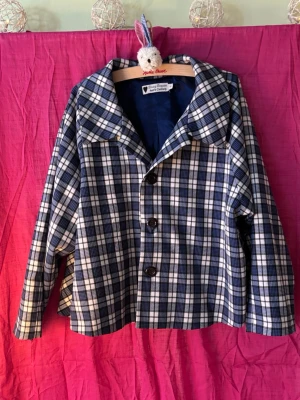 Retrokavaj Daisy Dapper - Blå- och vitrutig, söt retrokavaj/jacka i 50-talsstil med blått fint foder. Mycket bra skick, endast använd en gång. 