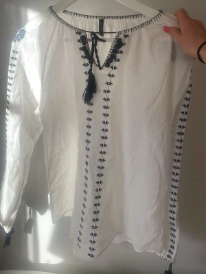 Mönstrad blus - En superfin blus med vackra blåa mönster på. Den är tunn i materialet så passar perfekt inför sommaren när det är lite varmare eller redan nu på våren! Jag vill också tillägga det man ser på sista bilden att det är ett litet hål, men syns inte eftersom det är två tofsar i vägen!