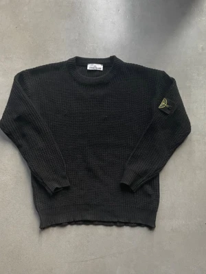 Stone Island Neule - Säljer en svart stickad tröja från Stone Island. Tröjan har en ikonisk logga på vänster ärm och är tillverkad i grovstickat material. Perfekt för dig som gillar stilrena plagg med attityd. Tröjan är storlek S-M. Jag är själv 180 och den passar bra! Hör av dig vid fundering.