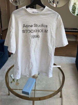  Acne Studios T-shirt - Vit t-shirt från Acne Studios med tryck 'Acne Studios STOCKHOLM 1996' på framsidan. Köpt på Nk där jag har kvar taggen som även medföljer🫱🏼‍🫲🏻 hör av er om minsta frågor