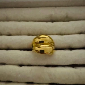 Guldfärgad chunky ring - Säljer en snygg guldfärgad ring med chunky design och rundad form. Ringen har en blank yta och är perfekt för dig som gillar statement-smycken. Ingen synlig märkning på ringen.