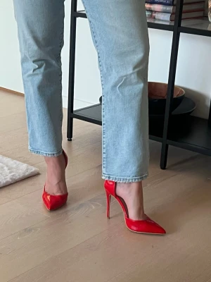 Röda lackpumps med hög klack - Snygga röda pumps i lack med spetsig tå och riktigt hög smal klack. Skorna har en klassisk och elegant form som ger en stilren look. Perfekta för dig som vill sticka ut och addera färg till outfiten.