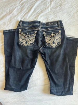 Low waist bootcut LA Idol jeans  - Superfina vintage La idol jeans i super bra skick- enda defekten är en sten som saknas på bakfickan (sista bilden). Storlek 7, skulle uppskatta de till en W28 och passar bra i längden på mig som är 171cm🫶🏼 lågmidjade och bootcut