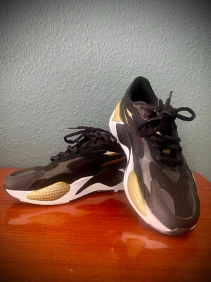  Puma SR - X  sneakers - Snygga sneakers från Puma med svart mesh och syntetmaterial, detaljer i guld och vit sula. OBS! Ingen innersula- lätt att åtgärda. 