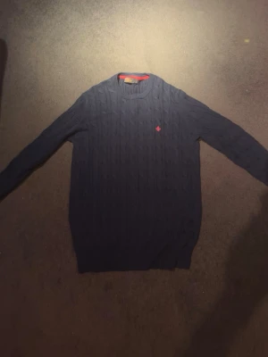 Morris Tröja - Säljer en marinblå kabelstickad tröja från Morris tröja i fint skick. Klassisk modell som passar både till vardag och lite mer uppklätt, den är knappast använd. Storlek: M, Skick: 8-9/10. Hör av er vid frågor/funderingar