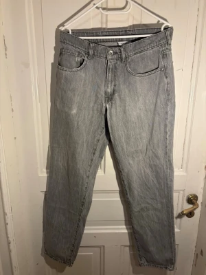 Grå jeans från Vailent, baggy modell - Säljer ett par grå jeans från Vailent i baggymodell. Jeansen har klassisk femficksdesign och är tillverkade i denim. Perfekta för dig som gillar en enkel och stilren look.