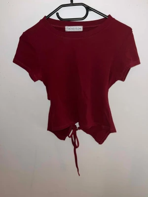 Röd tröja med knyt bakom - Röd tröja med knyt bakom, tröjan är från Thailand. Har använt 1-2 gånger så det är i bra skick. Står ingen storlek men jag tror de är strl S. Skriv om du har frågor.