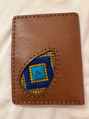 Brun läder plånbok med broderad detal - Säljer en brun plånbok i skinn med en unik broderad detalj. Handgjord