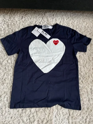 Svart t-shirt från Comme des Garçons Play - En mörkblå t-shirt från Comme des Garçons, sällsynt modell, riktigt snygg! Fraktar inom 48 timmar!