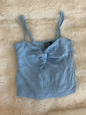 Blått linne - Sött blått linne från pieces med snygg detalj framtill. Är i storlek xs men skulle säga att den mer är xxs. Knappt använd.