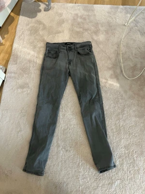 Gråa slim fit jeans från replay hyperflex - Säljer ett par gråa slim fit jeans från replay med klassisk femficksdesign och snygga detaljer på bakfickorna. Jeansen har en rak passform och är tillverkade i mjukt denim-material. Perfekt för dig som gillar en stilren look. Waist 30 length 30