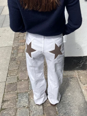 vita stjärn jeans design by si - vita super snygga jeans med bruna stjärnor baktill, från Design by Si i storlek M. tecken på användning och slitage, (bild 4 & 5) skriv vid intresse eller frågor!💕 nypris 605kr 